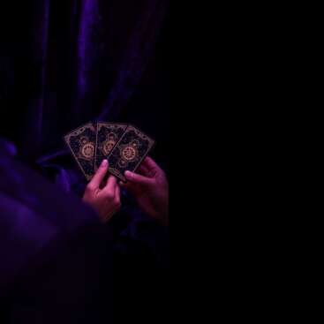 Zwei Personen betrachten eine 3-Karten Tarot-Legung für schnelle Klarheit im edlen schwarz-violetten Design.