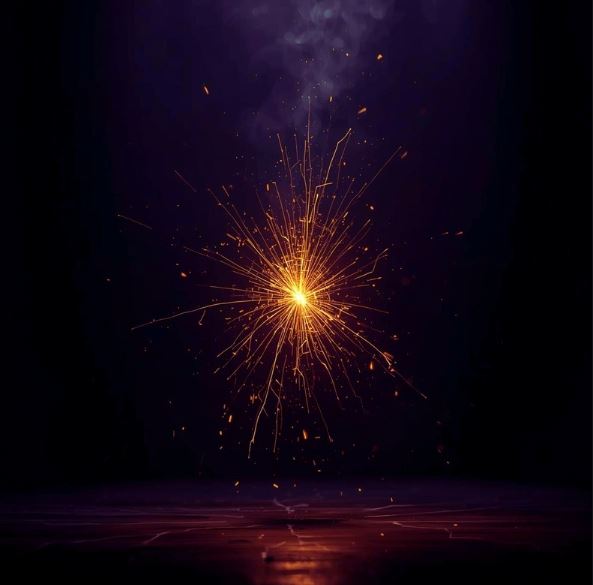 Goldener Manifestations-Funke auf Anthrazit. Info: Der Ursprung der Schöpfung.