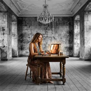 Frau im Boho-Stil mit ätherischen Ölen am Laptop, auf dem Bildschirm eine Frau, die Öl aus den Händen inhaliert, im Burgzimmer